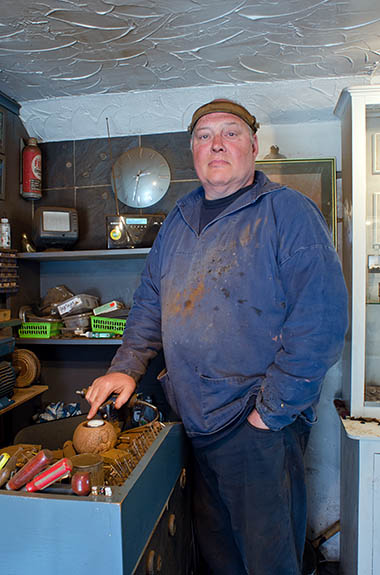 ENG: Yorkshire & Humberside Region, North Yorkshire, North Yorkshire Coast, Whitby, Whitby Jet Heritage Centre, Hal Redvers-Jones, jet craftsman and jewelry restorer, proprietor of the centre, stands beside his workbench [Ask for #270.194.]