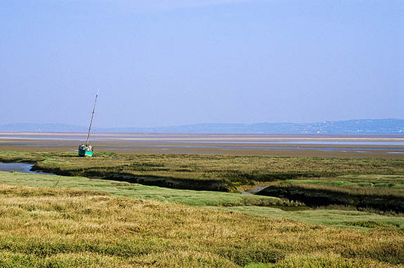 WAL: Northern Region, Flintshire County, The Dee Coast, Flint, Dee Estuary, Tidal channel at low tide, with a sailing boat resting on the grassy tidal flats; sand flats in bkgd. [Ask for #246.087.]