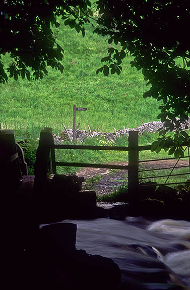 ENG: West Midlands Region, Staffordshire, Peak National Park, The River Dove, Beresford Dale, Footbridge crosses the River Dove; footpath sign by a stone wall in meadows on the other side [Ask for #246.234.]