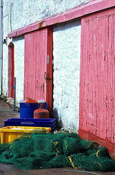 SCO: Argyll & Bute , Inner Hebrides, Islay, Port Askaig, 18th c. storage sheds, used by fishermen, line the village quay. [Ask for #246.520.]