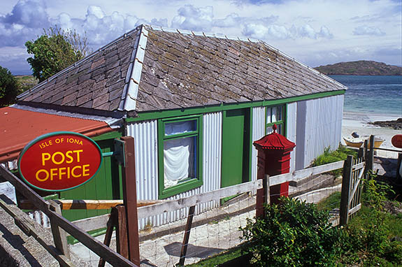 SCO: Argyll & Bute , Inner Hebrides, off Mull, Isle of Iona, Baile Mor (village). Village post office, in a brightly painted tin building on the beach; sign "Isle of Iona Post Office" [Ask for #246.602.]