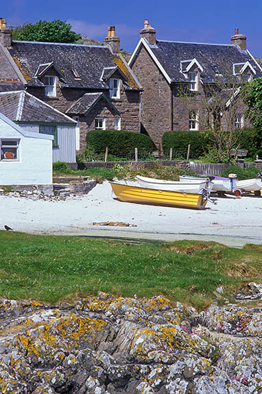 SCO: Argyll & Bute , Inner Hebrides, off Mull, Isle of Iona, Baile Mor (village). Main street of village, facing a white sandy beach with wood rowboats between rocky outcrops [Ask for #246.605.]