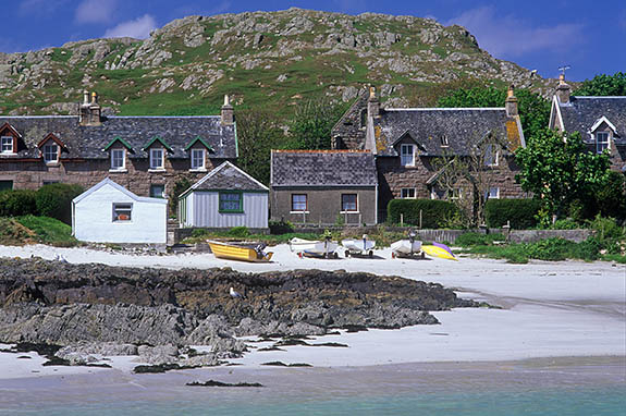 SCO: Argyll & Bute , Inner Hebrides, off Mull, Isle of Iona, Baile Mor (village). Main street of village, facing a white sandy beach with wood rowboats between rocky outcrops [Ask for #246.609.]