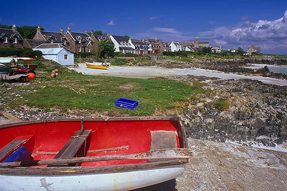 SCO: Argyll & Bute , Inner Hebrides, off Mull, Isle of Iona, Baile Mor (village). Main street of village, facing a white sandy beach with wood rowboats between rocky outcrops [Ask for #246.612.]