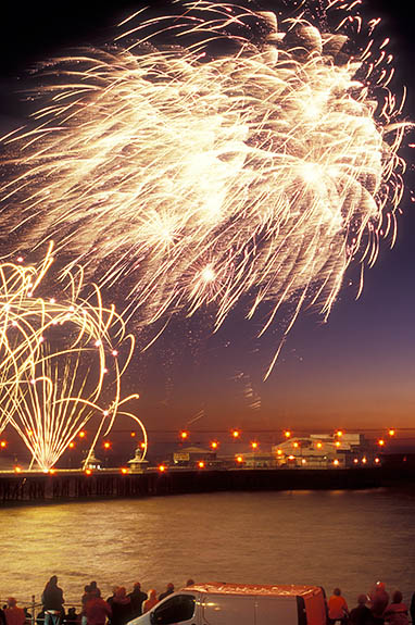 ENG: Blackpool Borough, Central City, Historic Town Center, International Fireworks Competition at the Illuminations Festival; people crowd along the seawall as fireworks explode over the pier [Ask for #262.081.]