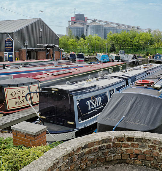 ENG: West Midlands Region, Staffordshire, The Trent Valley, Burton-on-Trent, The Trent and Mersey Canal, Industrial continuity; the canal port responsible for the Marstons and Bass brewery sites of the 1850s is still in use beneath the barley silos of Coors [Ask for #270.245.]