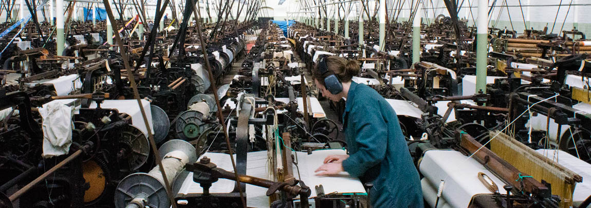 ENG: The Northwest Region, Lancashire, The Pennines, Burnley Borough, Briercliffe, Queen Street Mill, A docent runs a belt-powered loom on a fully functioning factory floor of this steam-powered Victorian textile plant [Ask for #270.394.]