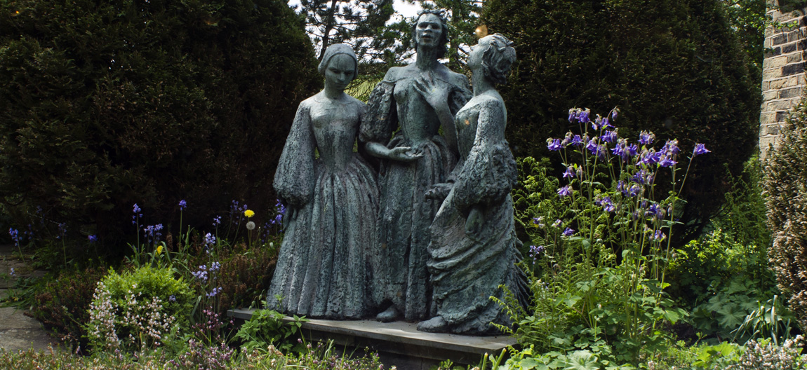 ENG: Yorkshire & Humberside Region, West Yorkshire, Bradford Borough, Haworth, Bronte Parsonage Museum, Statue of the Bronte sisters in the museum garden [Ask for #270.407.]
